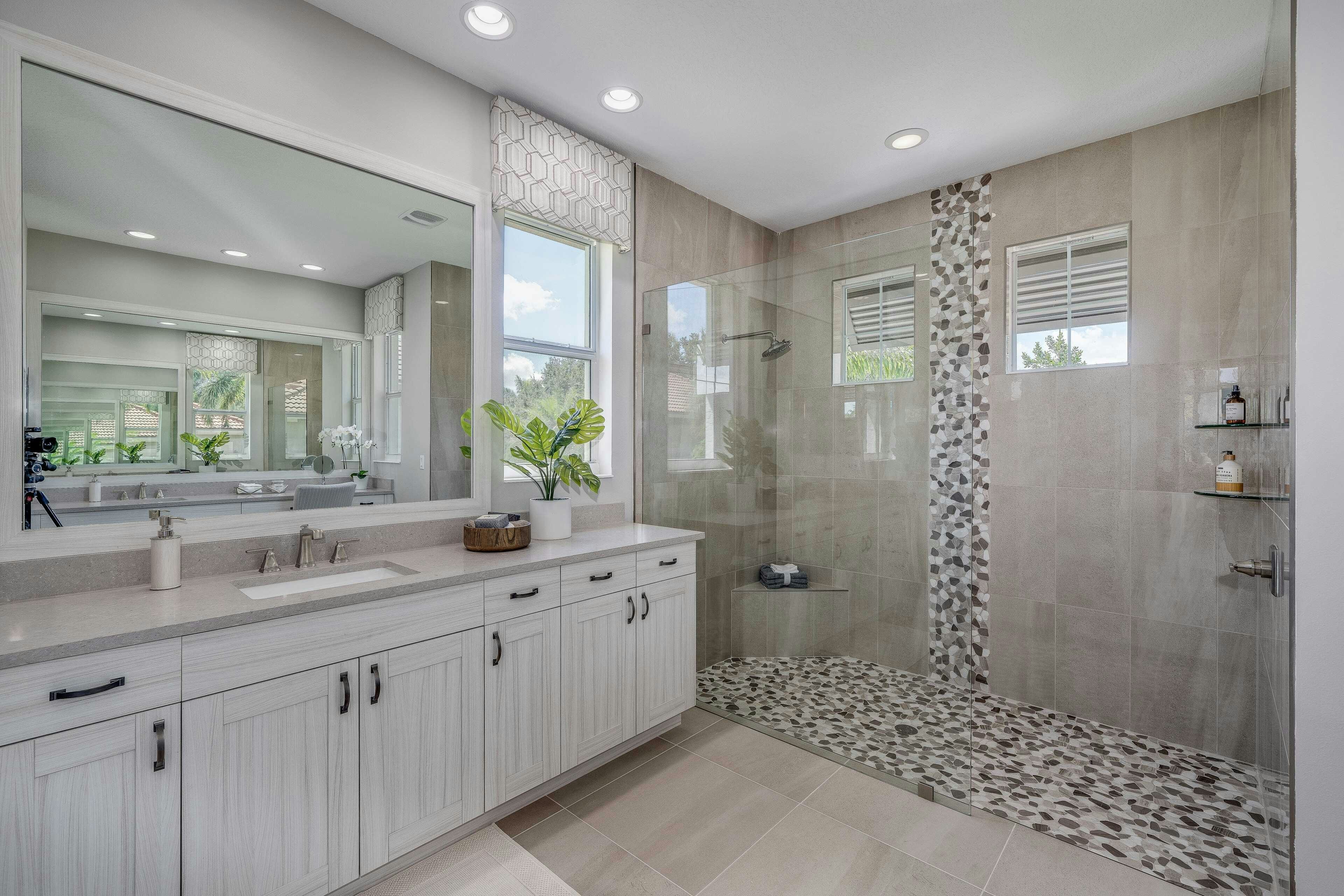 Master Bath with long vanity, walk -in shower with pebble floor and listello