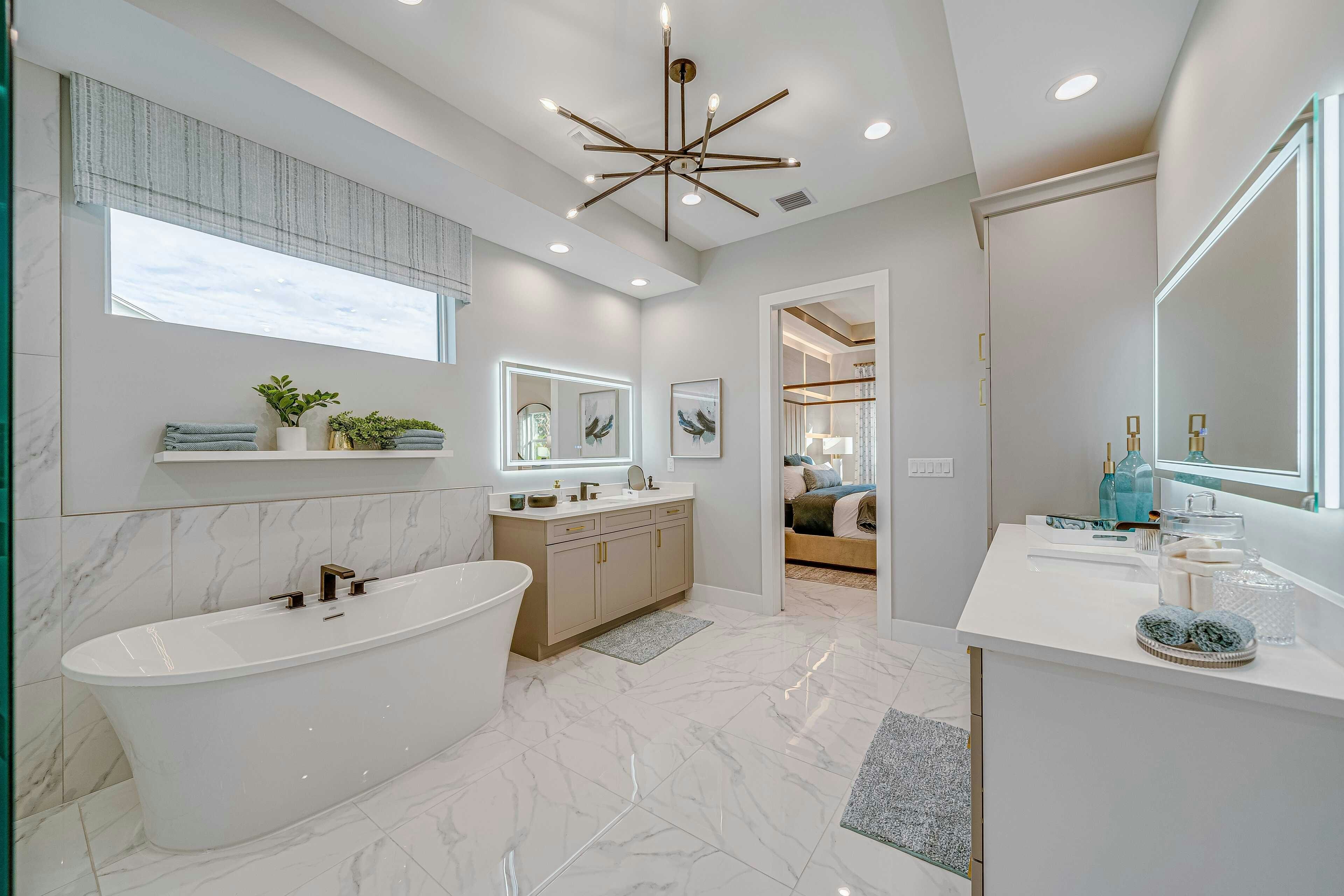 Master bath with soaker tub, split vanity, porcelain tile flooring and elegant chandlier