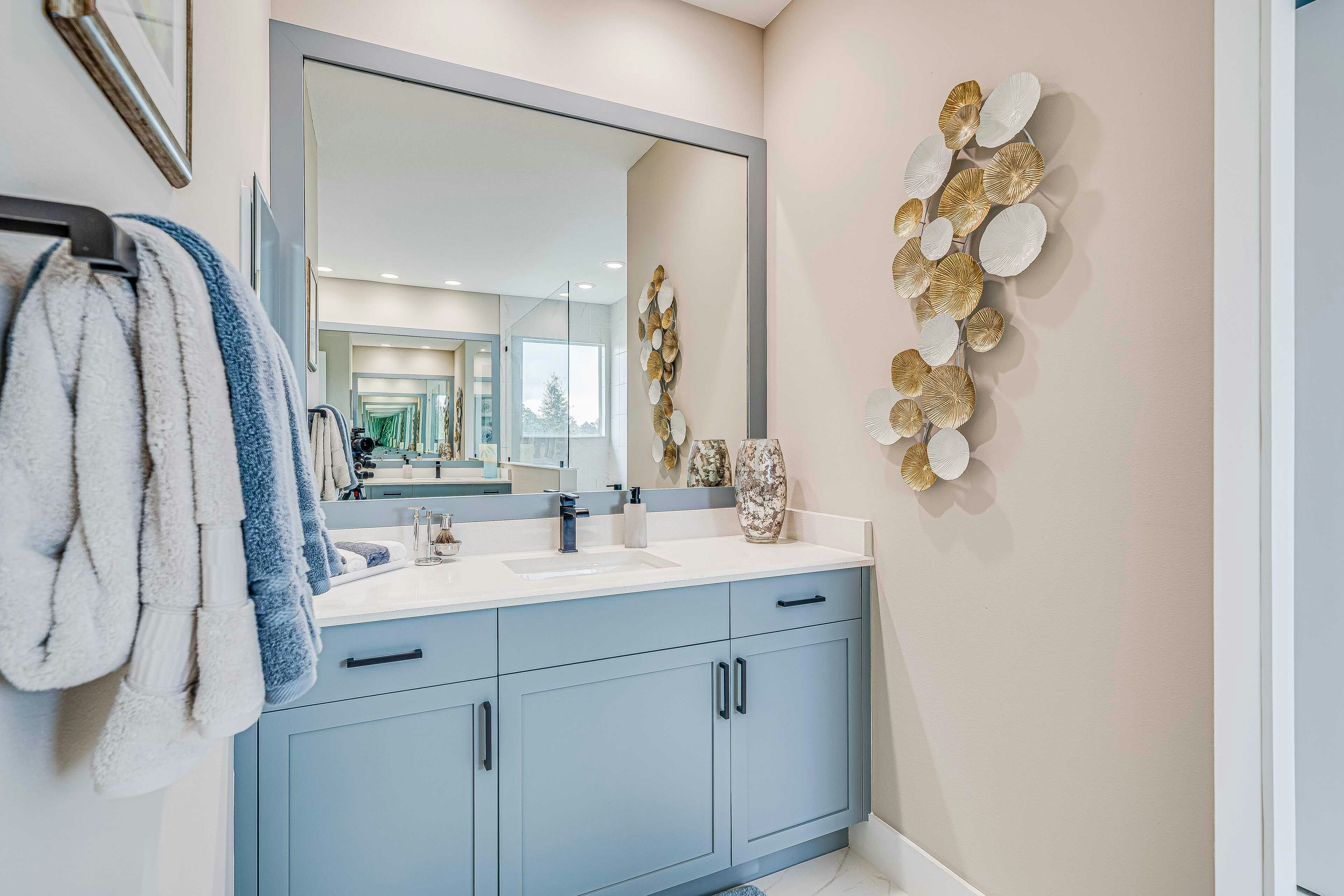 Master bath single vanity in with light blue cabinet and black accents