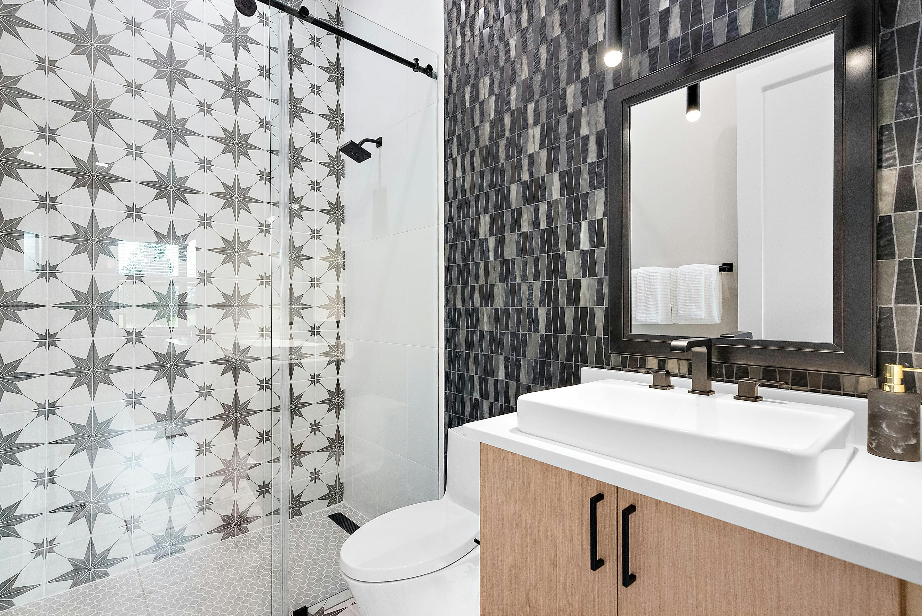Mosaic black wall detail in a secondary bath