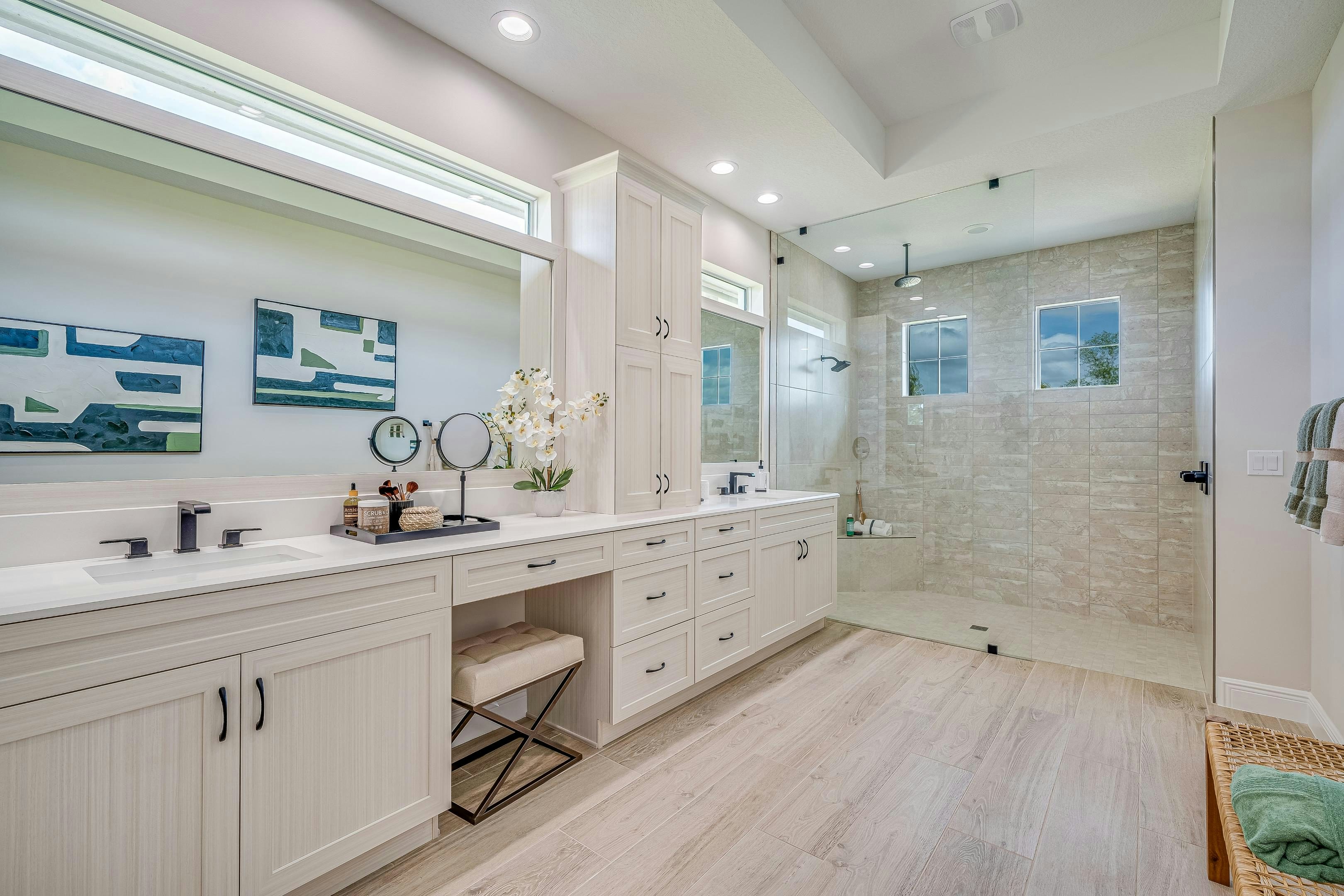 Master bath with wood tile flooring, walk-in shower and dual vanity with tower